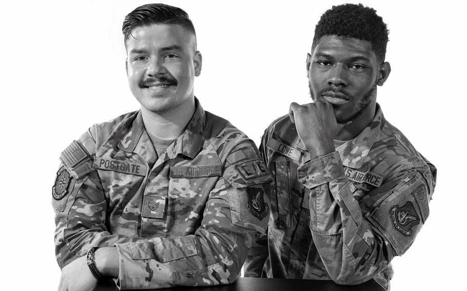Two airmen in uniform pose for a photograph.