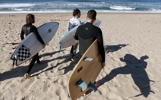 Braden Walker, left, Lawrence Doherty and Ryan Fonseca prepare to surf at Westward Beach in Malibu to kick off the “California Double.”