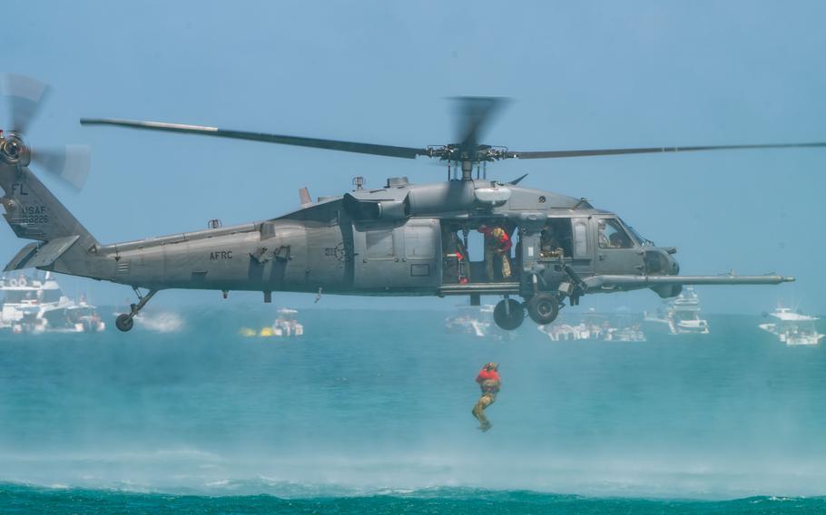 A Pararescueman jumps out of an HH-60G Pave Hawk helicopter