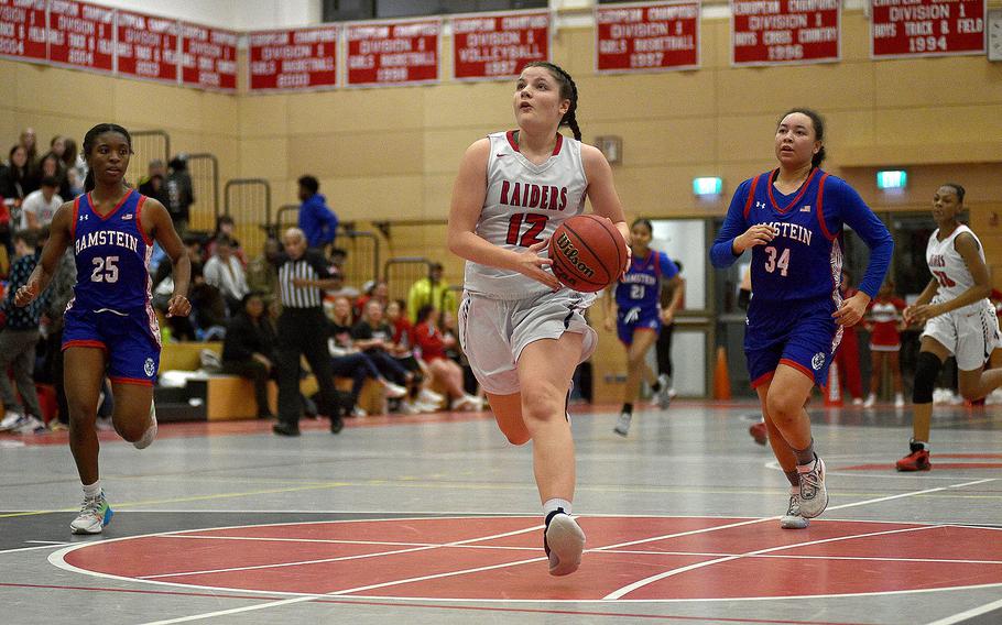 Kaiserslautern's Katya von Eicken picks up the ball to go up for a layup on the fast break during a Dec. 14, 2023, game against Ramstein at Kaiserslautern High School in Kaiserslautern, Germany. Trailing the play are, from left, Royals Bralyn Jones and Sanai Schneider.