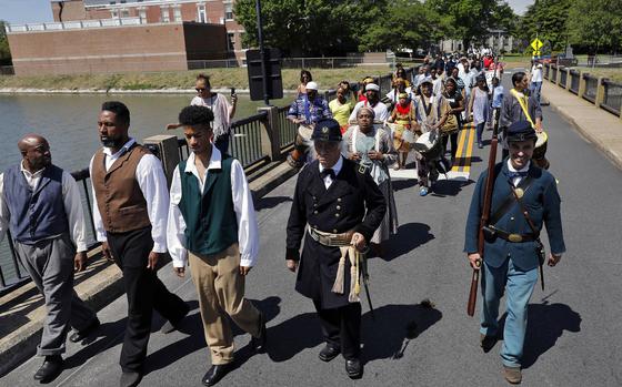 Members of the Contraband Historical Society, African dancers and drummers, re-enactors and members of the community walk to the Parade Ground at Fort Monroe during Saturday's Escape to Freedom event May 4, 2019. The event, hosted by the Contraband Historical Society, featured speeches from descendants of contrabands, performances and music to honor the legacy of the thousands of enslaved Africans who journeyed to Fort Monroe seeking asylum.