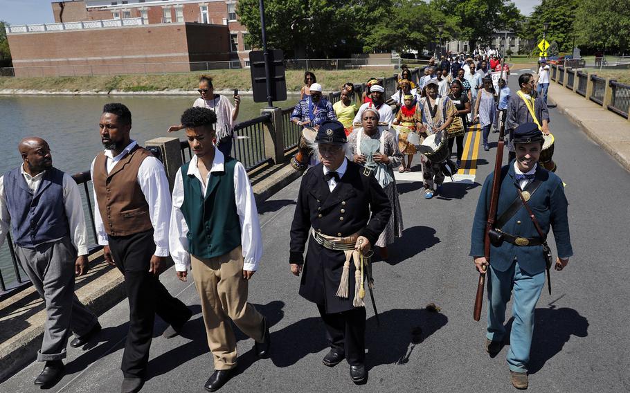 Members of the Contraband Historical Society, African dancers and drummers, re-enactors and members of the community walk to the Parade Ground at Fort Monroe during the Escape to Freedom event May 4, 2019.