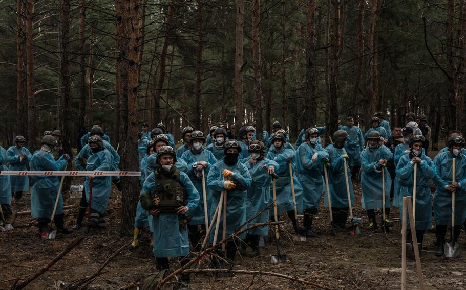 Military and police investigators start the exhumation of a mass grave site in Izyum, Ukraine.