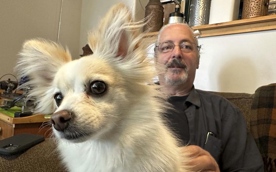 James Pelletier holds his dog, a papillon-Chihuahua mix named Lilly, at his Seattle home on June 30, 2023. Pelletier has tried various methods to help Lilly get through the stress of July Fourth fireworks, including placing sound-dulling foam over a basement window and playing loud recorded synthesizer sounds in an attempt to drown out the fireworks sounds. 