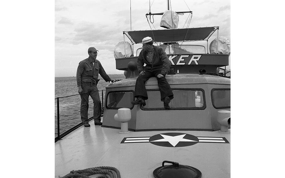 Staff Sgt. William M. Sparks (left) chats to another crew member of the 7th Crash Rescue Boat Flight aboard the “Joker,” one of the four 63-foot converted PT boats that provide marine rescue services in the event of an air crash at sea. The sleek crafts are equipped with 1,000 hp Hall-Scott engines and have a top speed of about 40 knots. Cruising at about 25 knots, they are capable of staying at sea for approximately 30 hours. Stripped of the armament they carried as PT boats, the craft now contain 10 cots and are equipped with a dispensary. 