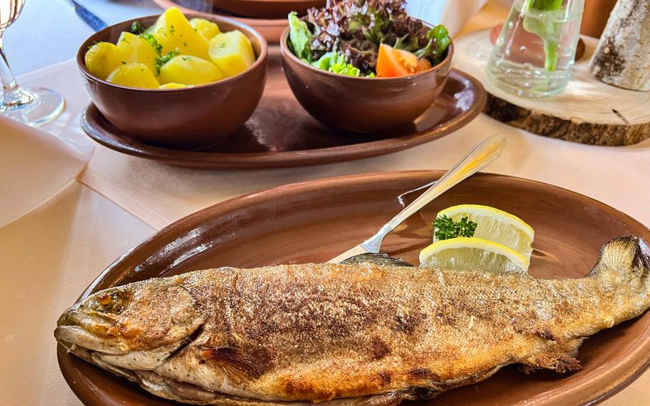 Grilled European brown trout is served with buttered potatoes and side salad in the tavern at Roman Villa Borg on May 2, 2023. The restaurant offers a variety of Roman dishes, including seasonal fare, in a cozy atmosphere.