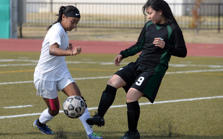 E.J. King's Miu Best battles Nagoya International's Misaki Oyama for the ball during Friday's Western Japan Athletic Association girls soccer tournament. The Cobras won 8-0.