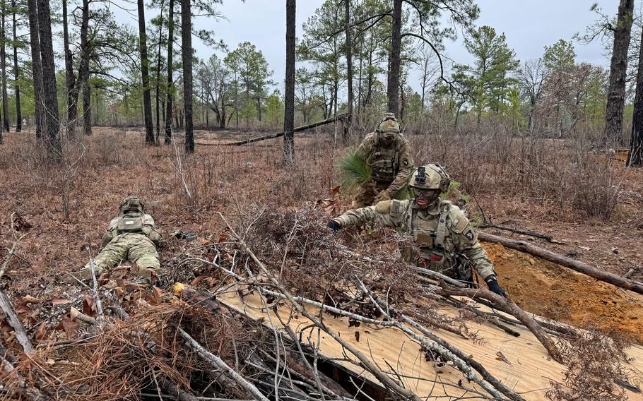 Soldiers use sticks and leaves to conceal a fighting position at the Joint Readiness Training Center. The war in Ukraine has reemphasized the importance of camouflage for soldiers on the ground. 