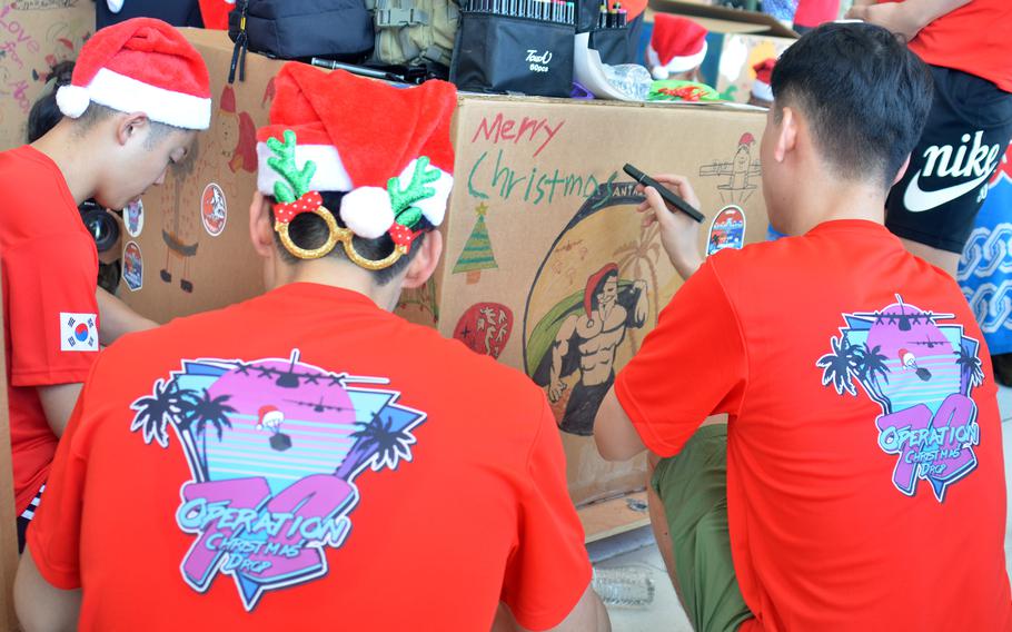 South Korean airmen decorate an Operation Christmas Drop bundle at Andersen Air Force Base, Guam, Saturday, Dec. 2, 2023. 