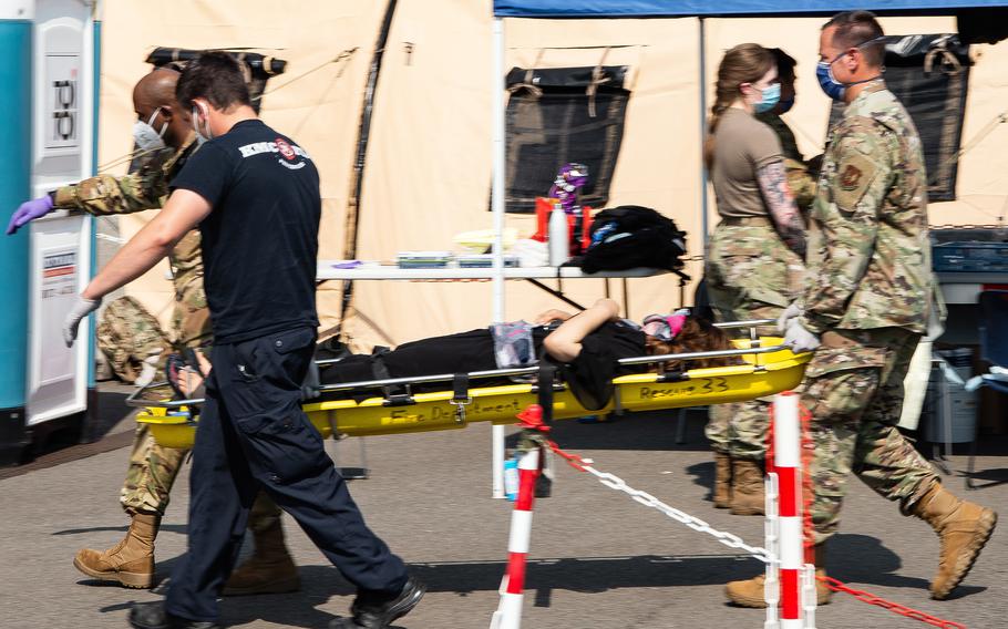 Airmen from the 86th Airlift Wing carry an Afghan mother to a medical tent moments after airmen and Army medics aided in the delivery of her child aboard a U.S. Air Force C-17 upon landing at Ramstein Air Base, Germany, Aug. 21, 2021.