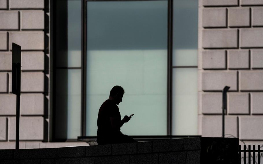 A pedestrian with a mobile phone in San Francisco on March 21, 2022.