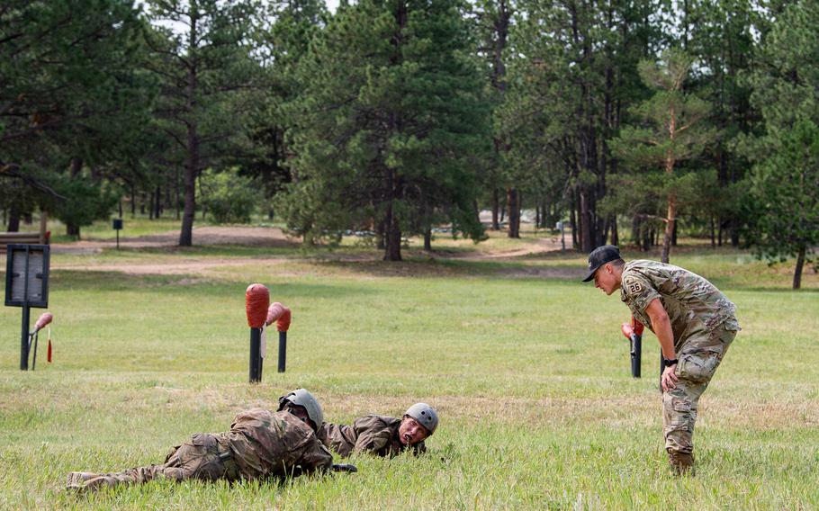 An instructor yells at two cadets on the ground