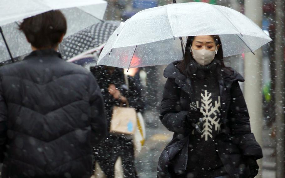 Snow falls near Tokyo Station on Thursday, Feb. 10, 2022. The city has counted more than 18,000 new COVID-19 infections for three days in a row. 