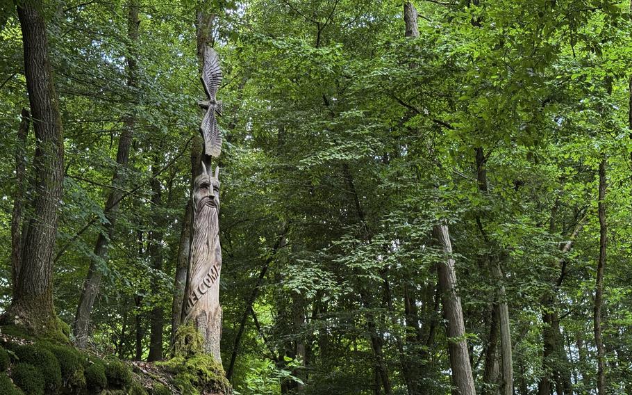 A tree trunk with a devil’s face carved into it.