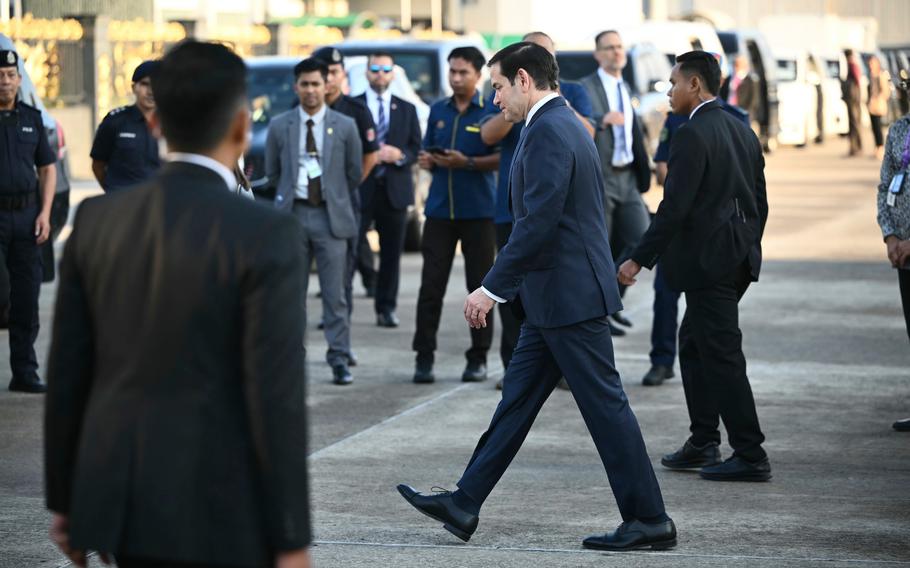 Marco Rubio in a suit walking through a crowded area.
