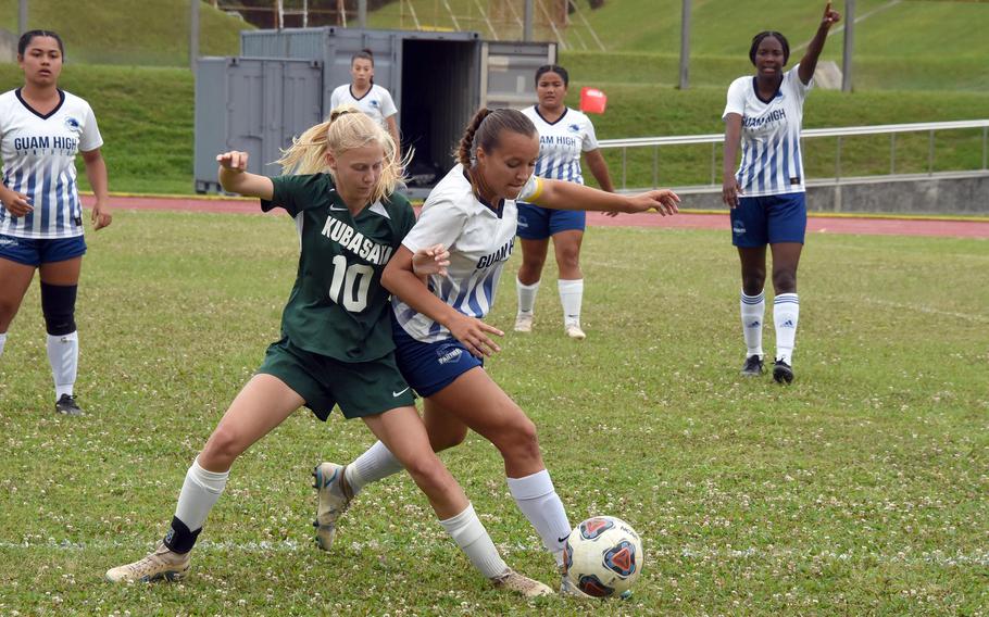 Kubasaki's Hailey Stoudemayer and Guam High's Zoie Terrill scuffle for the ball.