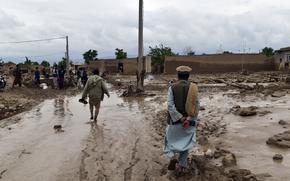 People are seen near to their damaged homes after heavy flooding in Baghlan province in northern Afghanistan Saturday, May 11, 2024. Flash floods from seasonal rains in Baghlan province in northern Afghanistan killed dozens of people on Friday, a Taliban official said. (AP Photo/Mehrab Ibrahimi)