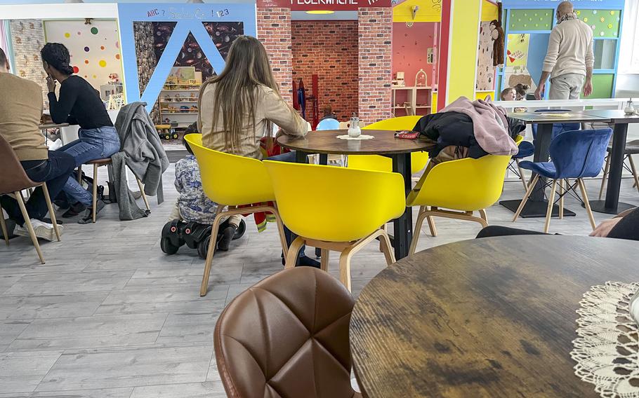 A view of the town play area from the cafe with round tables and chairs  