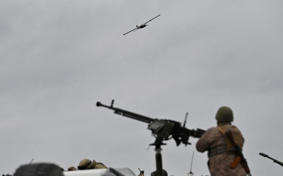 A Ukraine service member stands behind a machine gun as a drone flies during an anti-drone drill in Chernigiv region on Nov. 11, 2023. 