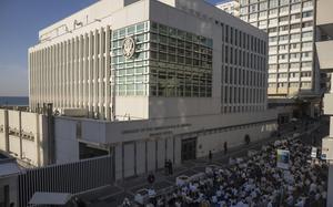 A crowd gathers outside the embassy building.