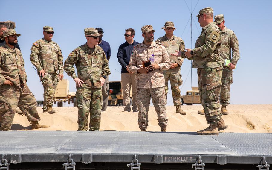 Soldiers are briefed before a semi-autonomous vehicle demonstration at Camp Buerhing, Kuwait, on July 25, 2023. The 371st Sustainment Brigade was testing the vehicles, which could form Army convoys in future war zones.