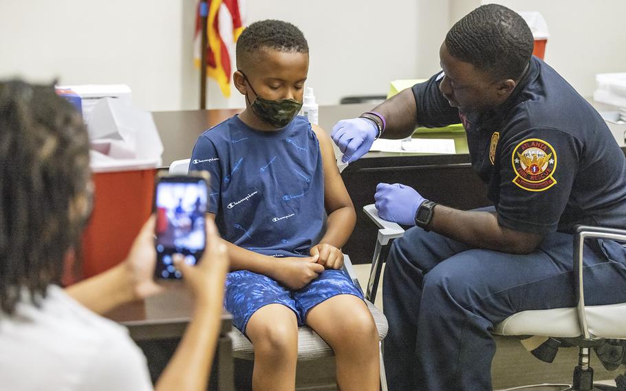 Xavier James, 11, gets ready to receive a COVID-19 shot as his mother takes his photograph during a vaccine event at Atlanta City Hall on June 25, 2022. 