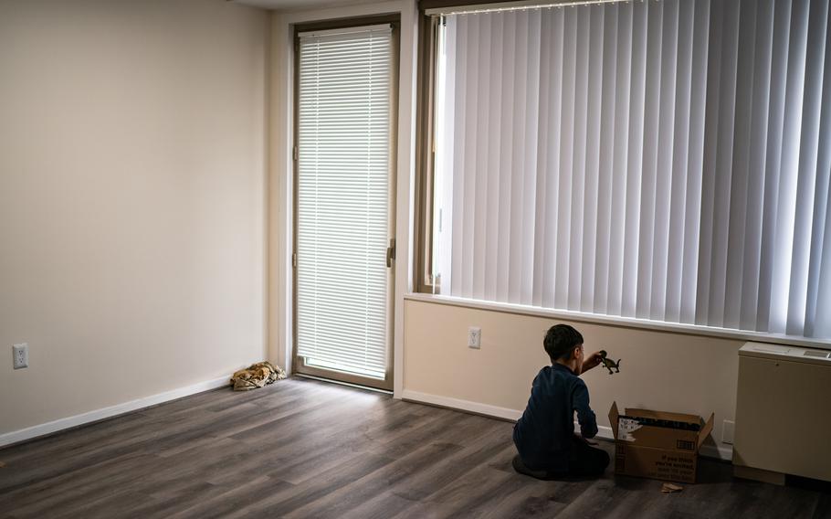 An Afghan child plays with donated toys in his family's empty living room in Falls Church, Va., on Dec. 6. The family is looking for a resettlement agency to sponsor them. 