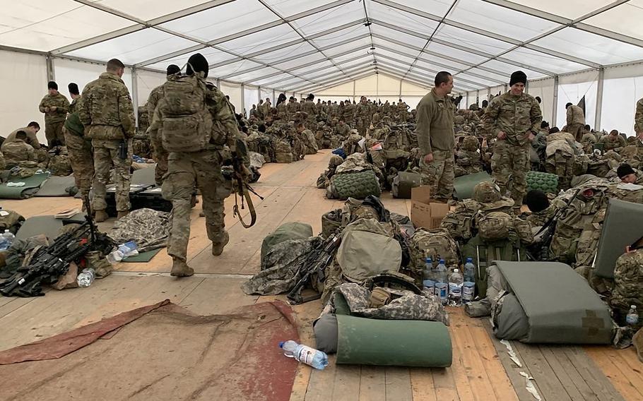 U.S. Army paratroopers of the 3rd Brigade Combat Team, 82nd Airborne Division, place their equipment inside a tent as they settle in to their new location in southeastern Poland, Feb. 19, 2022.