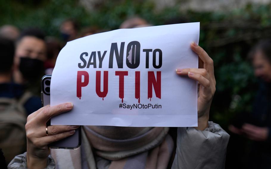 A woman holds up a sign in support of Ukraine during a demonstration in front of the Russian embassy in Paris, France, Tuesday, Feb. 22, 2022. 