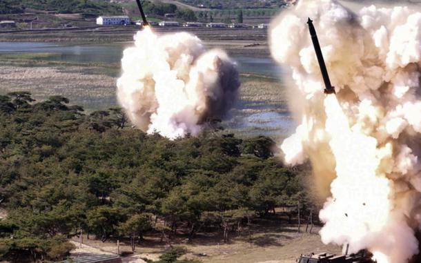 Two short-range ballistic missiles launch near water.