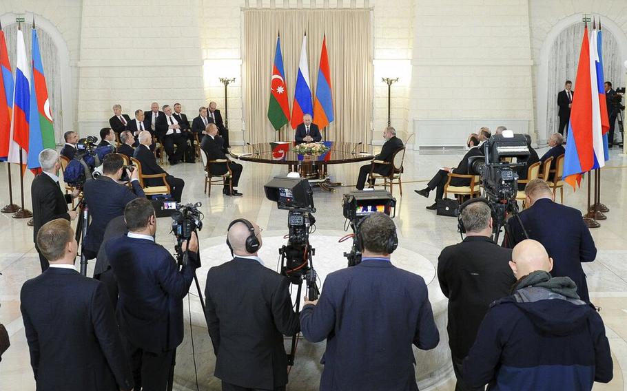 Russian President Vladimir Putin, background center, Azerbaijan’s President Ilham Aliyev, background left, and Armenian Prime Minister Nikol Pashinyan, background right, meet in the Black Sea resort of Sochi, Russia, Monday, Oct. 31, 2022. 