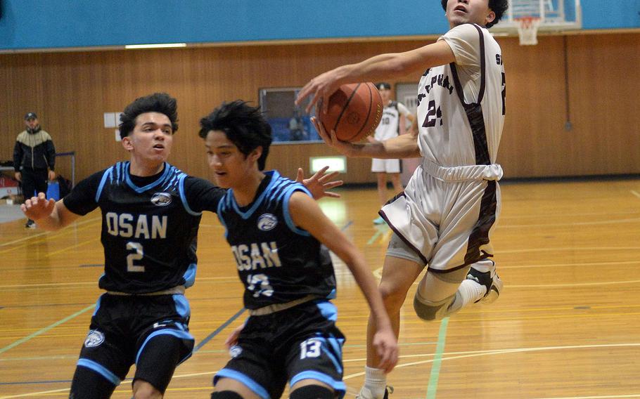 Matthew C. Perry's Kameron Ramos drives to the basket on Osan defenders M.J. Siebert and R.J. Jones. The Samurai won 63-33.