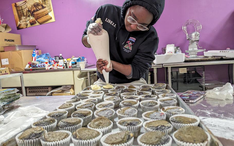 A culinary specialist in the 10th Mountain Division at Fort Drum, N.Y., decorates cupcakes for a Thanksgiving meal for soldiers and family members, Tuesday, Nov. 21, 2023.