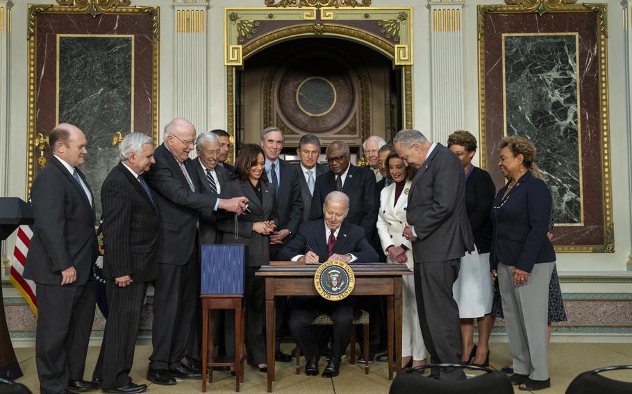 President Joe Biden, joined by Vice President Kamala Harris, Acting Director of the Office of Management and Budget Shalanda Young, second from right, and congressional leadership, signs the Consolidated Appropriations Act of 2022, Tuesday, March 15, 2022, in the Indian Treaty Room of the Eisenhower Executive Office Building at the White House.