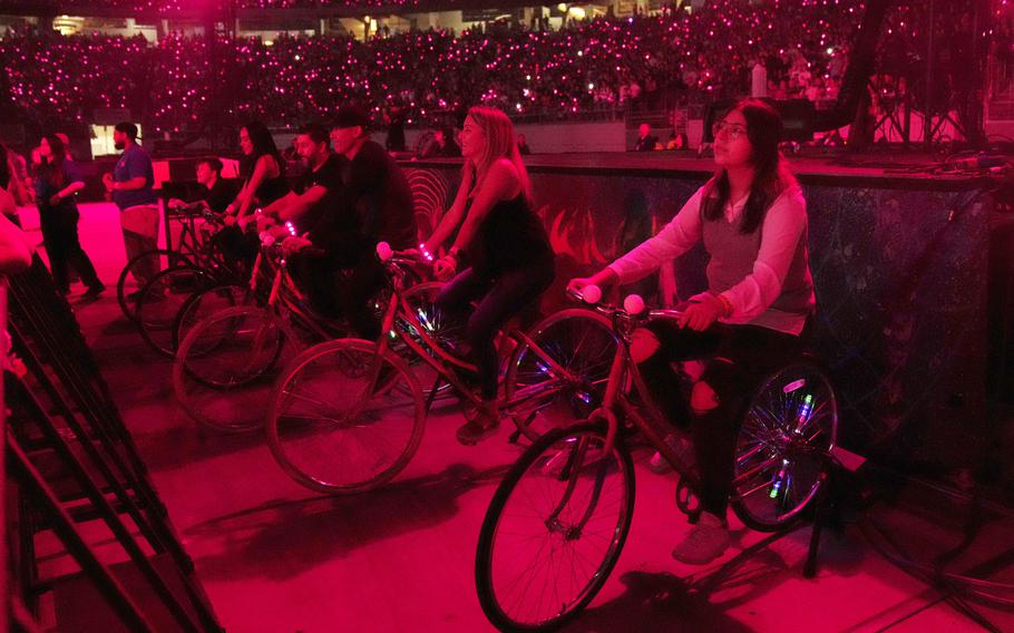 Concertgoers ride stationary bikes May 12 during Coldplay’s Music of the Spheres world tour at State Farm Stadium in Glendale, Ariz. The band has included energy-storing stationary bikes to their latest world tour, encouraging fans to help power the show as part of a push to make the tour more environmentally friendly.