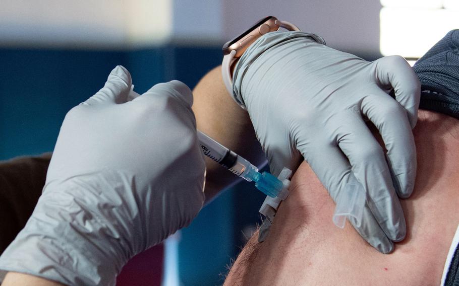 A family health technician administers a dose of COVID-19 vaccine to an airman at Aviano Air Base, Italy, in February, 2021. Some U.S. military bases opened vaccinations to all tiers of eligible beneficiaries Monday, but few had available appointments. 