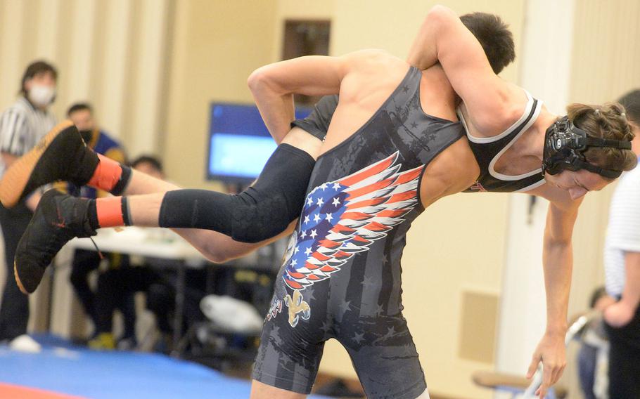 Kubasaki's Jeff Owens hoists Yokota's Tate Rannow on high at 145 pounds during Tuesday's Azabu Ward year-end international open wrestling tournament. Rannow rallied to pin Owens at 2 minutes, 45 seconds, and went on to take second in the division.
