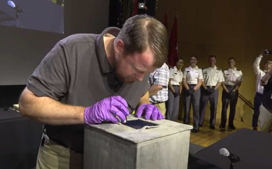 Paul Hudson, an archaeologist at the U.S. Military Academy at West Point, N.Y., on Aug. 28, 2023, peers into a time capsule from 1828 that was discovered a few months ago at the school.