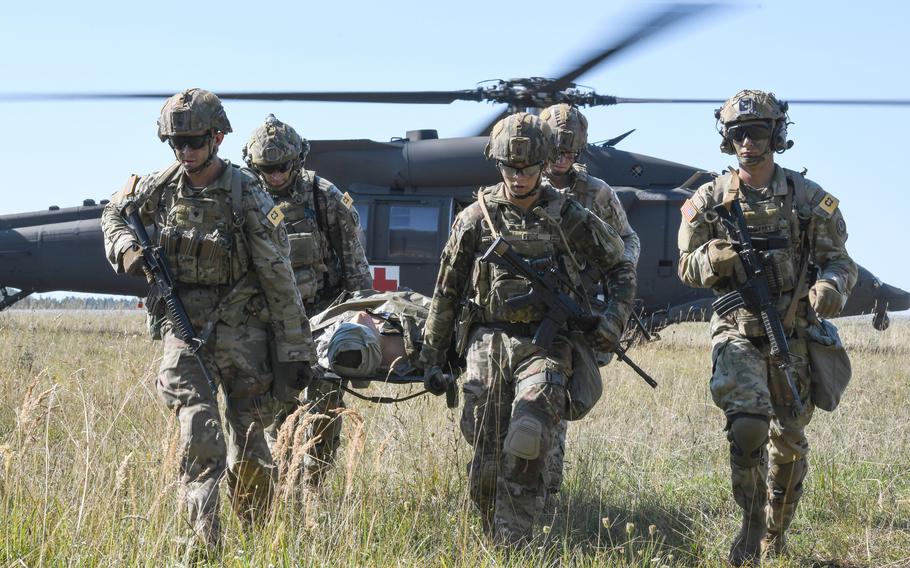 U.S. soldiers assigned to V Corps team carry a mannequin to a secure area during the U.S. Army Europe and Africa Best Squad competition at Grafenwoehr Training Area, Germany, Aug. 9, 2022. 