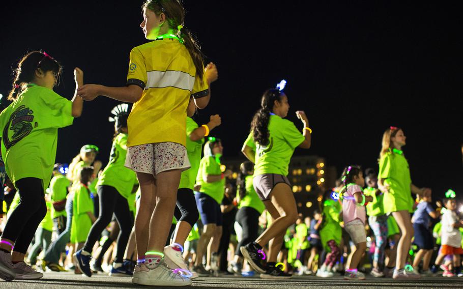 Runners warm up with a Zumba session ahead of a neon fun run at Atago Sports Complex in Iwakuni city, Japan, Saturday, June 24, 2023.