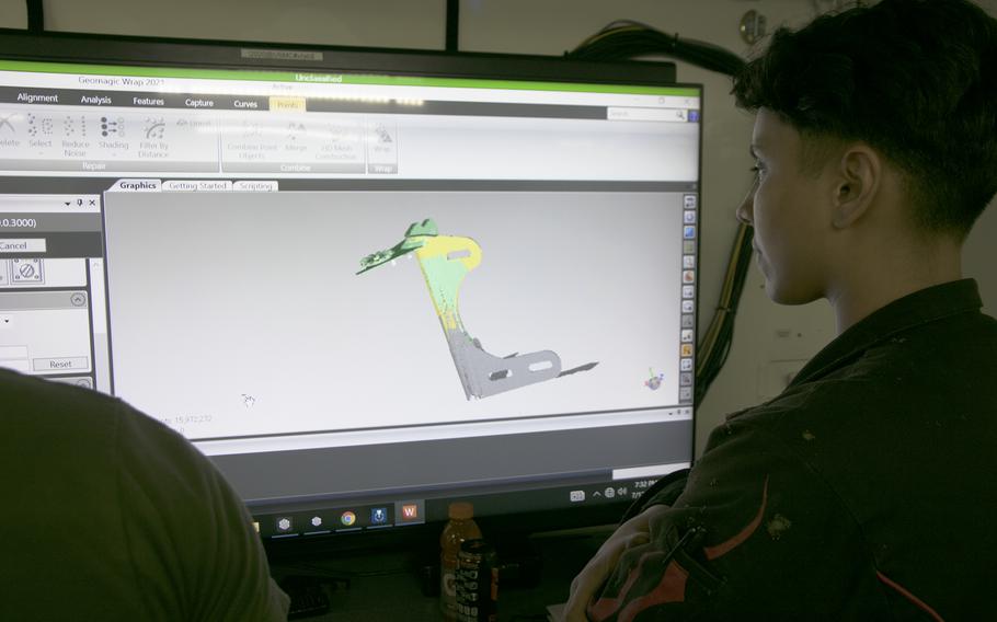 A Marine watches the monitor as a FARO 3D scanner captures the dimensions of a mirror bracket for a 7-ton truck inside the new expeditionary fabrication shop at Camp Kinser, Okinawa, on July 13, 2022.