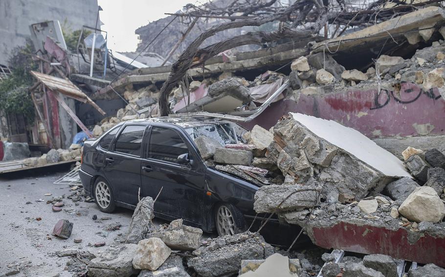 Debris from a destroyed building covers a car in Hatay, Turkey, on Feb. 8, 2023.