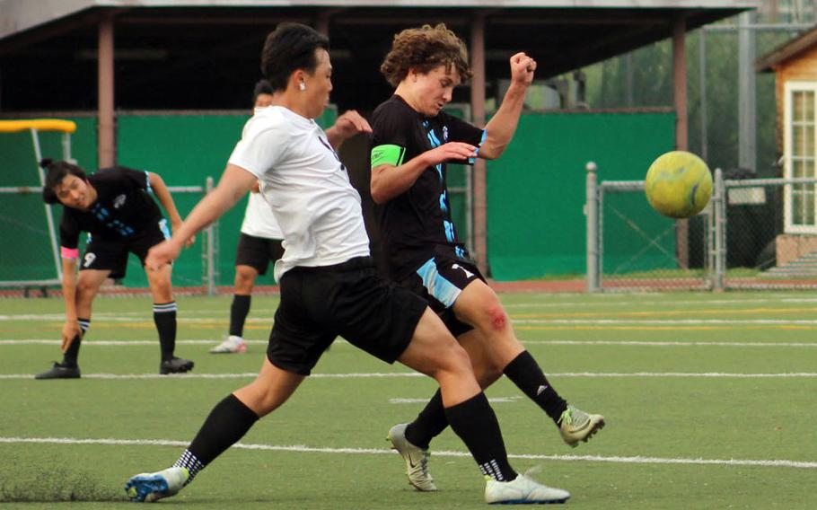 Daegu’s David Tak and Osan‘s Reid Iverson try to play the ball during Friday’s DODEA-Korea boys soccer match. The Warriors won 4-1.
