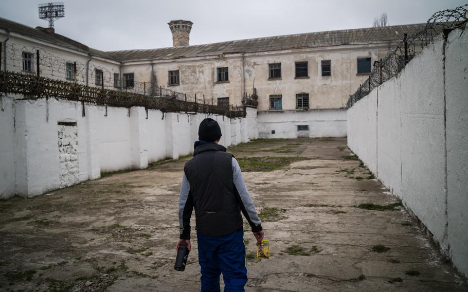 A man walks Sunday in the yard of a prison in Kherson, Ukraine, where he said Russian jailers killed prisoners for disobedience or for being suspected resistance fighters.