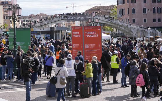 Stewards check tourists QR code access outside the main train station in Venice, Italy, Thursday, April 25, 2024. The fragile lagoon city of Venice begins a pilot program Thursday to charge daytrippers a 5 euro entry fee that authorities hope will discourage tourists from arriving on peak days. The daytripper tax is being tested on 29 days through July, mostly weekends and holidays starting with Italy's Liberation Day holiday Thursday. Officials expect some 10,000 people will pay the fee to access the city on the first day, downloading a QR code to prove their payment, while another 70,000 will receive exceptions, for example, because they work in Venice or live in the Veneto region. (AP Photo/Luca Bruno)