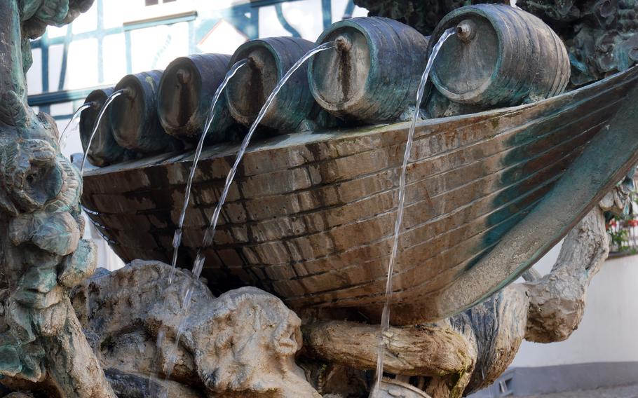 On a city fountain, water flows from wine barrels.