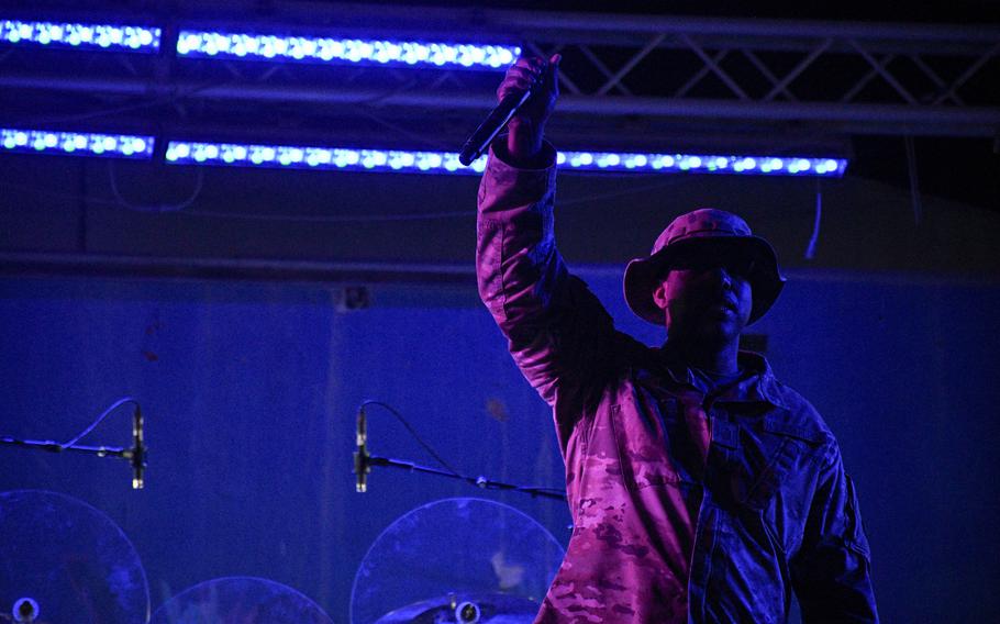 Air Force Master Sgt. Chris Jones, head operations sergeant for the 379th Security Forces Squadron, leads a cheer for the crowd at a ceremony in Al Udeid Air Base, Qatar, April 22, 2022. The event marked 20 years since the unit was reactivated.