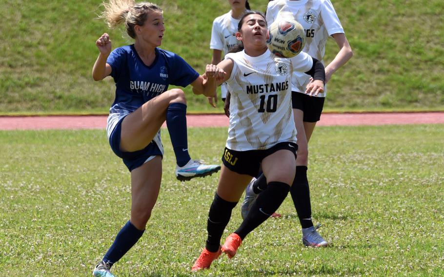 Guam High's Grace Martin and American School In Japan's Jenna Curtis battle for the ball during Tuesday's Division I girls soccer quarterfinal. The Panthers won 2-0.