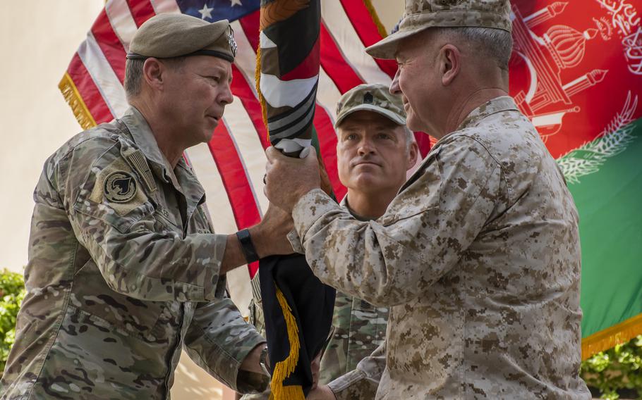 Gen. Scott Miller, left, hands command of U.S. forces in Afghanistan to Marine Corps Gen. Frank McKenzie at a ceremony in Kabul, Afghanistan on Monday, July 12, 2021.