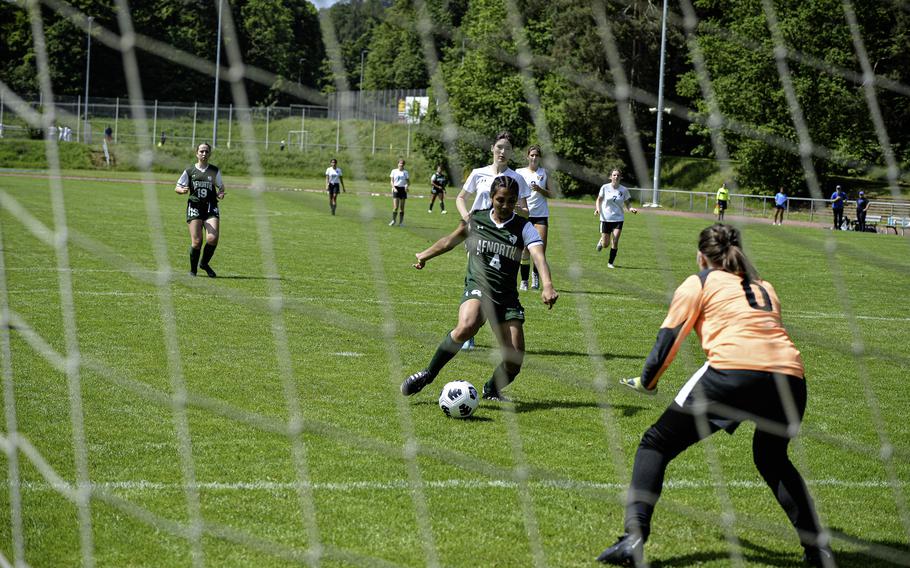 Selah Skariah of AFNORTH takes a shot at goal as Brussels goalie Lucia Martinez prepares to jump during the 2024 DODEA European Soccer Division III Championships in Landstuhl, Germany, on May 20, 2024.